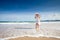 Happy teenage child in white dress on beach