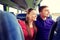 Happy teenage couple or passengers in travel bus