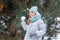 Happy teenage girl having fun playing with snowballs, ready to throw the snowball