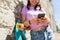 Happy teenage girl with longboard and smartphone