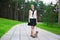 Happy teenage girl walking with dog yorkshire terrier in park