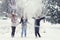 Happy teenage girls throwing snow in the air