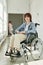 Happy teenage student with physical disability sitting in wheelchair