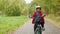 Happy teenager boy riding on bicycle in autumn park. Bicyclist boy cycling front camera in city park. Teenager boy