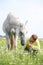 Happy teenager boy and white horse at the field