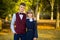 Happy teenager couple of high school students in festive school uniform on background autumn park. Beginning of lessons.