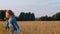 Happy teenager girl dancing at oat field. Cirl teenager walking on wheat field