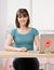 Happy teenager sitting at desk with laptop