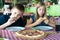 Happy teenagers eating pizza in a cafe. Friends or siblings having fun in restaurant