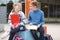 Happy teenagers schoolboy and schoolgirl sitting on schoolyard and joyful talking