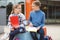 Happy teenagers schoolboy and schoolgirl sitting on schoolyard and joyful talking