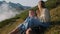 happy teens girls are sitting on slope of mount at summer vacation