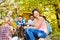 Happy teens hold marshmallow sitting on campsite