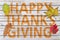 Happy Thanks Giving with four autumn leaf written on white wood