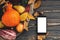 Happy Thanksgiving concept. Phone with empty screen and beautiful Pumpkin with bright autumn leaves, acorns, nuts, berries on woo