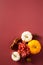 Happy Thanksgiving day concept. Flat lay pumpkins, flowers, walnuts, cinnamon sticks on dark red background