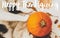 Happy Thanksgiving greeting card. Happy Thanksgiving text handwritten on cute cat holding paws on pumpkin, relaxing on warm