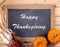 Happy Thanksgiving Text on Chalkboard Bordered With Pumpkins and Corn