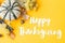 Happy thanksgiving text on pumpkin, autumn flowers, leaves on yellow background flat lay. Seasonal greeting card, handwritten sign