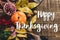 Happy thanksgiving text sign on autumn pumpkin with leaves and w