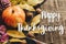 Happy thanksgiving text sign on autumn pumpkin with leaves and w