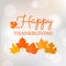 Happy thanksgiving typographic headline with maple leave on bokeh background