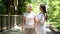 Happy therapist and senior lady with walking frame looking at each other in park