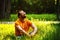 A happy thoughtful dreamer man is sitting on green grass in park