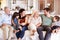 Happy three generation white family sitting on a sofa at home looking at each other, front view