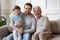 Happy three generations male family resting on couch.