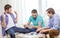 Happy three male friends playing poker at home