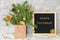 Happy Thursday text on black letter board and festive bouquet of fir branches with christmas decor in craft package on table.