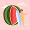 Happy tiny young man standing with surfboard on background huge ripe watermelon.