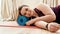 Happy to be active. Young curvy woman in sportswear smiling at camera while exercising using foam roller on a yoga mat