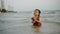 happy toddler baby girl playing sand and water on sea beach