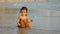 happy toddler baby girl playing toy and water on sea beach