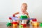 Happy toddler boy playing educational constructor himself close-up and copy space