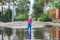 Happy toddler boy running through puddles in rubber boots. Child splashes after rain outside