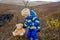 Happy toddler child, holding teddy bear, posing in front of beautiful waterfal Svartifossl in Skaftafell national park in Iceland