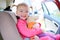 Happy toddler girl enjoying safe trip in the car