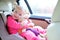 Happy toddler girl enjoying safe trip in the car