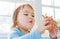 Happy toddler girl playing with potted plants