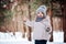 Happy toddler girl playing in winter forest with snow