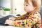 Happy toddler girl typing on her computer keyboard