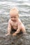 Happy toddler playing in the sea. Cute baby boy splashing in the black sea.