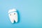 happy tooth on a blue background, copy space, oral care concept, toy tooth model, pediatric dentistry, teach a kid to brush his te