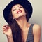 Happy toothy laughing brunette young woman in black hat with closed eyes. Closeup portrait of happiness. Vintage