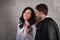 Happy toothy smiling business woman and thinking businessman in white shirts on loft style wall studio background. Love and flirt