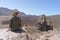 Happy tourist sitting in a rock of a viewpoint,with observation and relax in a volcanic desert