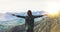 Happy tourist traveler stand on a rock with raised hands, hiker looking to a valley below in trip in spain, hipster young girl